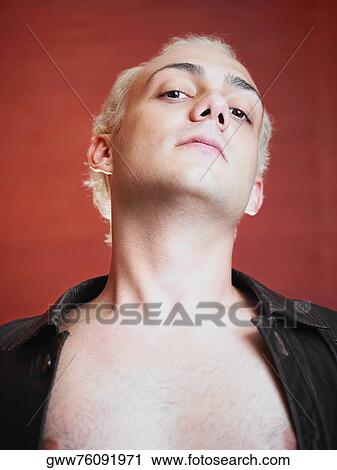 Stock Image - Portrait of a young man with his shirt unbuttoned. Fotosearch