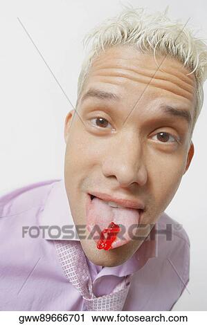 Stock Image - Portrait of a young man with sticking his tongue out. Fotosearch
