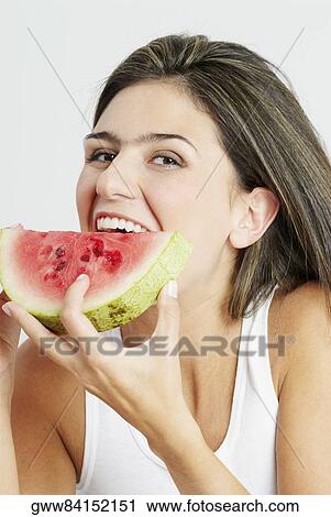 Portrait of a young woman eating a watermelon View Large Photo Image Stock Image - Portrait of a young woman eating a watermelon. Fotosearch