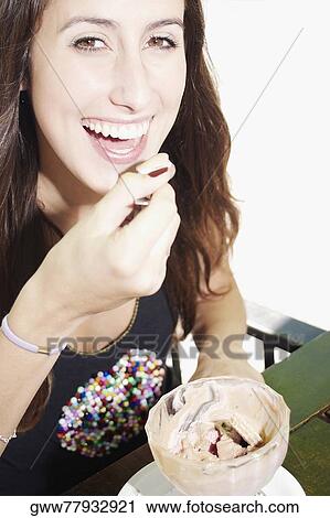 Portrait of a young woman eating an ice-cream sundae View Large Photo Image Stock Image - Portrait of a young woman eating an ice-cream sundae. Fotosearch