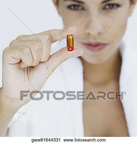 Portrait of a young woman holding a capsule View Large Photo Image Stock Image - Portrait of a young woman holding a capsule. Fotosearch