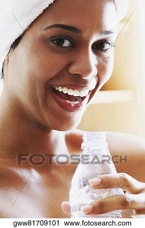 Portrait of a young woman holding a water bottle and laughing View Large Photo Image Stock Image - Portrait of a young woman holding a water bottle and laughing. Fotosearch