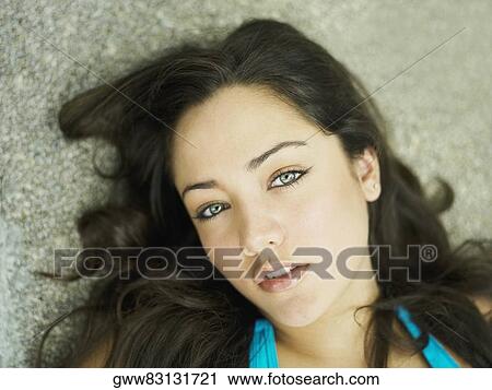 Stock Image - Portrait of a young woman lying on her back. Fotosearch