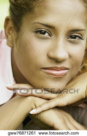 Stock Image - Portrait of a young woman lying on the grass. Fotosearch