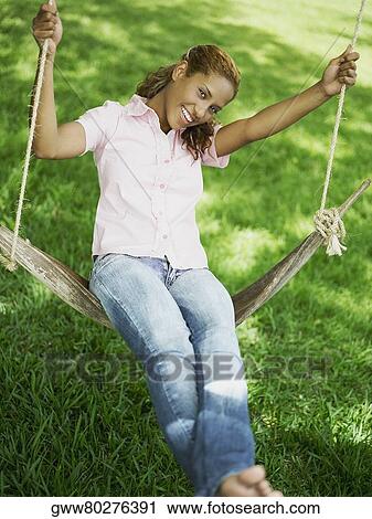 Portrait of a young woman swinging on a swing View Large Photo Image Stock Image - Portrait of a young woman swinging on a swing. Fotosearch