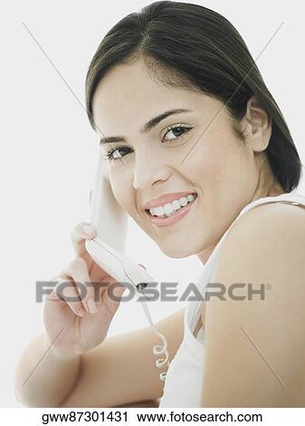 Portrait of a young woman using a telephone View Large Photo Image Stock Image - Portrait of a young woman using a telephone. Fotosearch