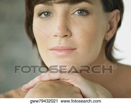 Portrait of a young woman with her hand on her chin View Large Photo Image Stock Image - Portrait of a young woman with her hand on her chin. Fotosearch