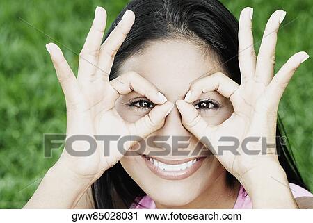 Portrait of a young woman with her fingers around her eyes View Large Photo Image Stock Image - Portrait of a young woman with her fingers around her eyes. Fotosearch