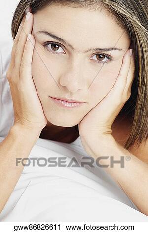 Portrait of a young woman with her hands on her chin View Large Photo Image Stock Image - Portrait of a young woman with her hands on her chin. Fotosearch