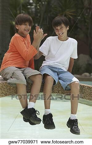 Portrait of two boys sitting on a footbridge across a pond View Large Photo Image Stock Image - Portrait of two boys sitting on a footbridge across a pond. Fotosearch