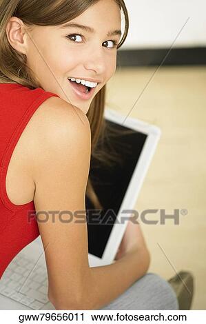 Rear view of a young woman using a laptop View Large Photo Image Stock Image - Rear view of a young woman using a laptop. Fotosearch