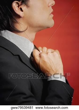 Side profile of a businessman adjusting his tie View Large Photo Image Stock Image - Side profile of a businessman adjusting his tie. Fotosearch