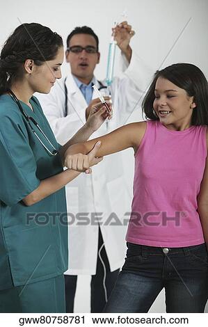 Side profile of a female doctor giving an injection to a girl View Large Photo Image Stock Image - Side profile of a female doctor giving an injection to a girl. Fotosearch