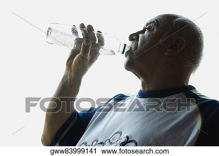 Side profile of a mature man drinking water from a bottle View Large Photo Image Stock Image - Side profile of a mature man drinking water from a bottle. Fotosearch