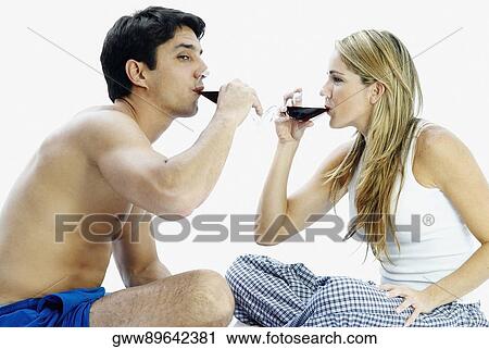 Side profile of a mid adult couple sitting and drinking red wine View Large Photo Image Stock Image - Side profile of a mid adult couple sitting and drinking red wine. Fotosearch