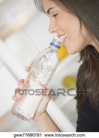 Side profile of a young woman drinking water View Large Photo Image Stock Image - Side profile of a young woman drinking water. Fotosearch