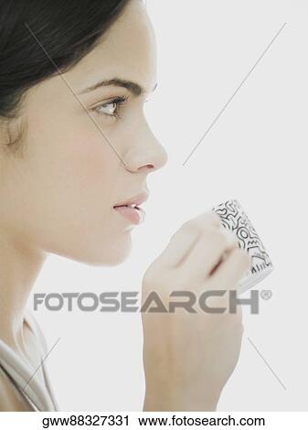 Side profile of a young woman holding a cup View Large Photo Image Stock Image - Side profile of a young woman holding a cup. Fotosearch
