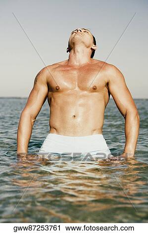 Young man standing in water View Large Photo Image Stock Image - Young man standing in water. Fotosearch