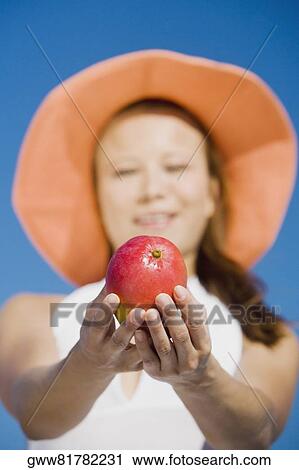 Young woman showing an apple View Large Photo Image Stock Image - Young woman showing an apple. Fotosearch