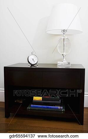Alarm clock and a lamp on a chest View Large Photo Image Stock Photo - Alarm clock and a lamp on a chest. Fotosearch