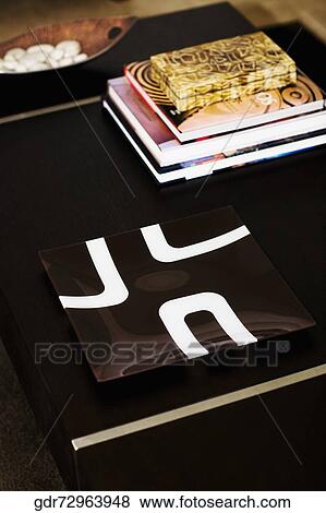 Books with a file on a table in a living room View Large Photo Image Stock Photo - Books with a file on a table in a living room. Fotosearch