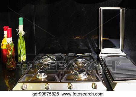 Stock Photography - Bottles of pickles near a gas stove. Fotosearch