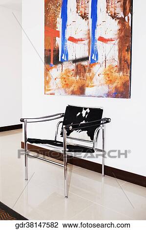 Chair with a painting in a room View Large Photo Image Stock Image - Chair with a painting in a room. Fotosearch