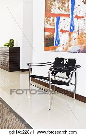 Chair with an abstract painting in a room View Large Photo Image Stock Image - Chair with an abstract painting in a room. Fotosearch