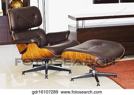 Stock Photo - Chair with an ottoman in a living room. Fotosearch