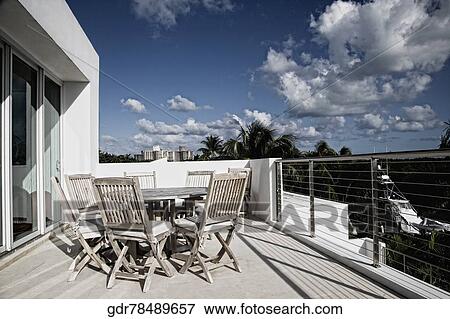 Chairs with a table in a balcony View Large Photo Image Stock Photo - Chairs with a table in a balcony. Fotosearch