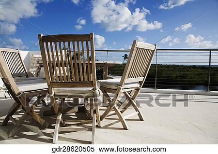 Chairs with a table in a balcony View Large Photo Image Stock Photography - Chairs with a table in a balcony. Fotosearch