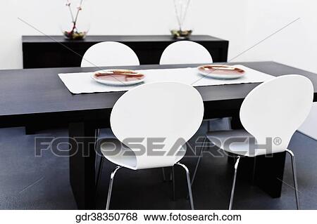 Chairs with a table in a dining room View Large Photo Image Stock Photo - Chairs with a table in a dining room. Fotosearch