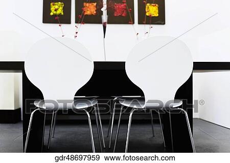 Chairs with a table in a dining room View Large Photo Image Stock Photo - Chairs with a table in a dining room. Fotosearch
