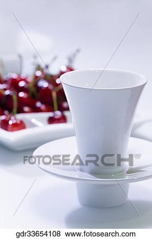 Stock Photo - Cherries in a tray with a tea cup. Fotosearch
