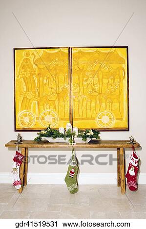 Stock Image - Christmas stockings hanging with a table. Fotosearch