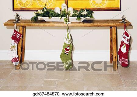 Stock Image - Christmas stockings hanging with a table. Fotosearch