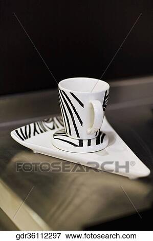 Stock Photo - Close-up of a cup with a tray on a table. Fotosearch