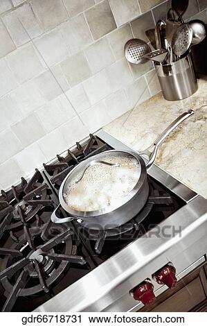 Stock Image - Close-up of a frying pan on a gas stove. Fotosearch