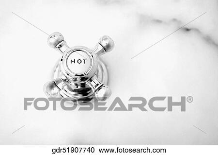 Stock Image - Close-up of a hot water shower knob. Fotosearch