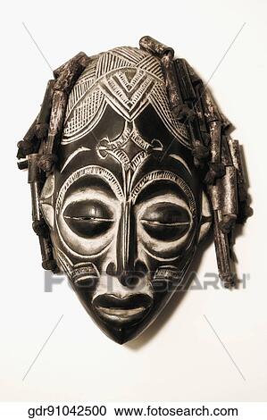 Stock Image - Close-up of a mask mounted on a wall. Fotosearch