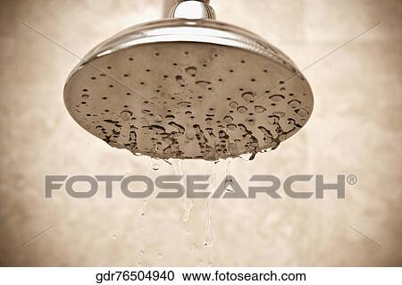 Stock Image - Close-up of a shower head with dripping water. Fotosearch