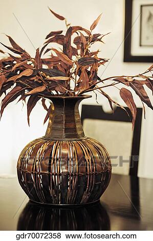 Close-up of a wooden vase with artificial leaves View Large Photo Image Stock Photo - Close-up of a wooden vase with artificial leaves. Fotosearch
