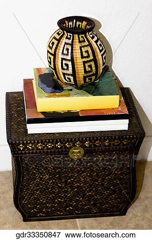 Close-up of books and a pot on a trunk View Large Photo Image Stock Photo - Close-up of books and a pot on a trunk. Fotosearch