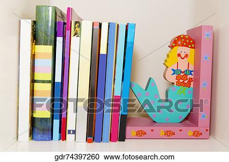 Close-up of books and toy mermaids on a shelf View Large Photo Image Stock Image - Close-up of books and toy mermaids on a shelf. Fotosearch