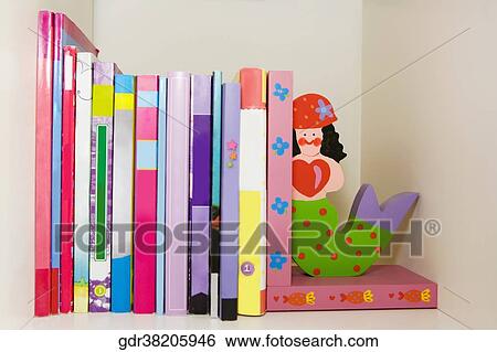 Close-up of books and toy mermaids on a shelf View Large Photo Image Stock Photograph - Close-up of books and toy mermaids on a shelf. Fotosearch