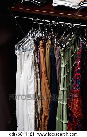 Clothes hanging in a closet View Large Photo Image Stock Image - Clothes hanging in a closet. Fotosearch