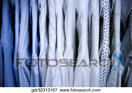 Clothes hanging in a row View Large Photo Image Stock Photo - Clothes hanging in a row. Fotosearch