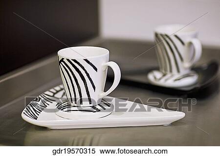 Stock Photography - Cups with trays on a kitchen counter. Fotosearch