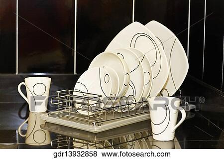 Dish rack on a kitchen counter View Large Photo Image Stock Photo - Dish rack on a kitchen counter. Fotosearch