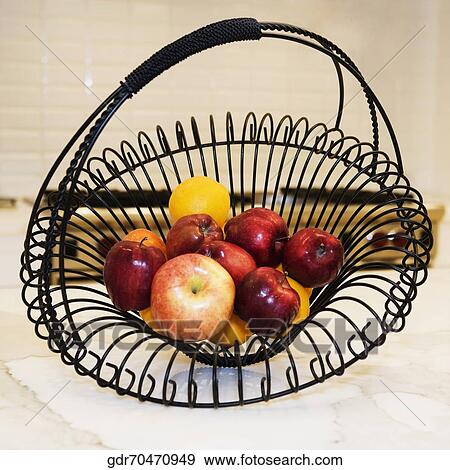 Stock Photo - Fruits in a basket on a kitchen counter. Fotosearch